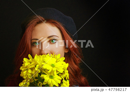 Woman holds a yellow chrysanthemum 47798217