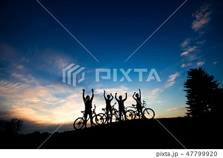 Silhouettes of cyclists standing on hill. Silhouettes of cyclists standing on hill. 47799920