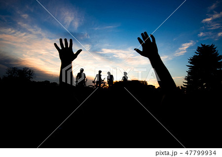 Silhouette of hands at sunset sky. 47799934