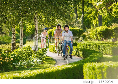 Happy students cycling outdoors. Happy students cycling outdoors. 47800341
