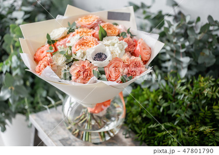 beautiful fresh cut bouquet of mixed flowers in vase on wooden table. The work of the florist at a beautiful fresh cut bouquet of mixed flowers in vase on wooden table. The work of the florist at a 47801790