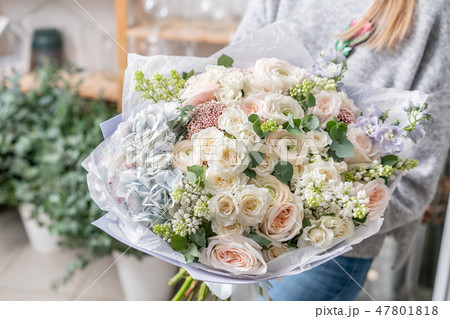 beautiful fresh cut bouquet of mixed flowers in woman hand. the work of the florist at a flower shop beautiful fresh cut bouquet of mixed flowers in woman hand. the work of the florist at a flower shop 47801818