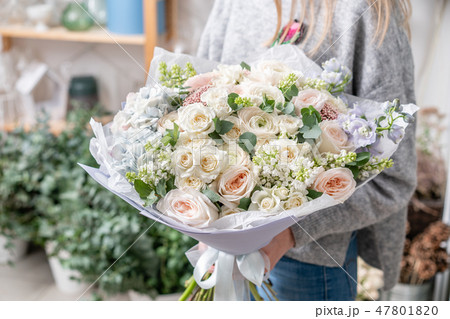 beautiful fresh cut bouquet of mixed flowers in woman hand. the work of the florist at a flower shop 47801820