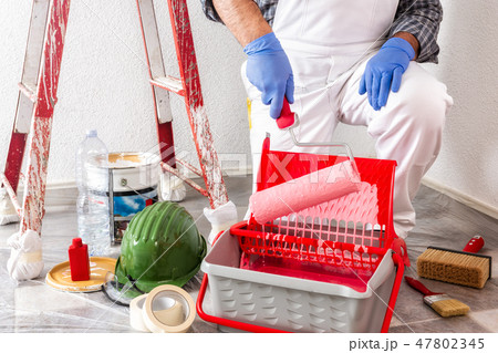Professional house painter at work with the roller 47802345