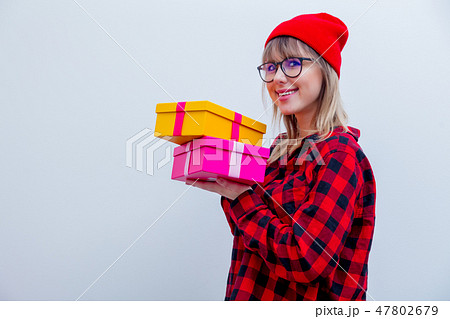 woman in red shirt and hat holding holiday gift boxes woman in red shirt and hat holding holiday gift boxes 47802679