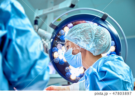 Close up portrait of young female surgeon doctor wearing protective mask and hat during the Close up portrait of young female surgeon doctor wearing protective mask and hat during the 47803897