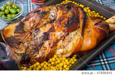 Tasty baked in oven pig ham with garbanzo at plate served 47806843