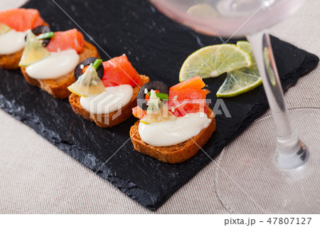 Toasted bread with creamy sauce, salmon and olives Toasted bread with creamy sauce, salmon and olives 47807127