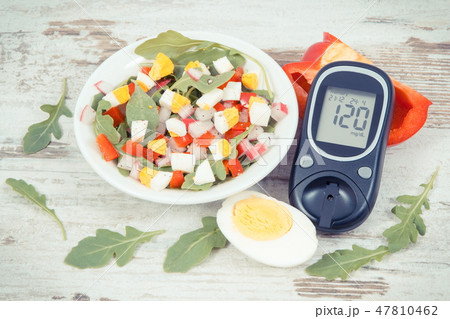 Glucometer with result of sugar level and salad 47810462