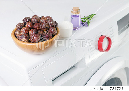 soap nuts in a bowl on the washing machine and lavender oil, detergent powder, selective focus 47817234
