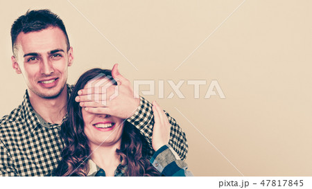 Man covering woman eyes for surprise. 47817845