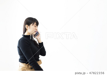 スマホで留守電を聞く若い女性 スマホで留守電を聞く若い女性 47822356