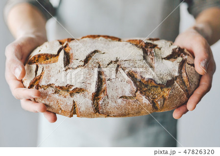 Baker or chef holding fresh made bread Baker or chef holding fresh made bread 47826320