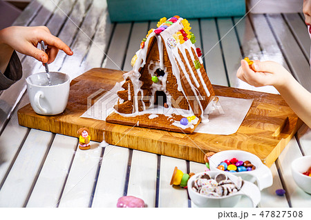 Familiy building a sweet ginger bread house Familiy building a sweet ginger bread house 47827508