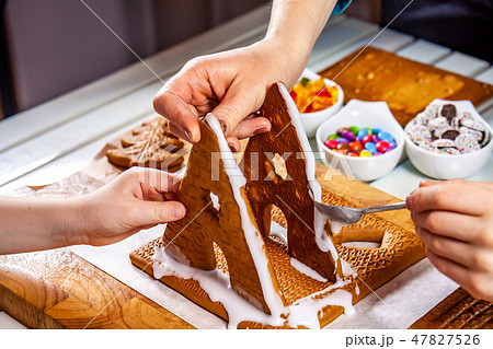 Familiy building a sweet ginger bread house 47827526