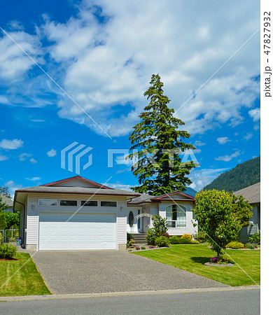 Nice family house with wide garage door on sunny day in British Columbia. 47827932
