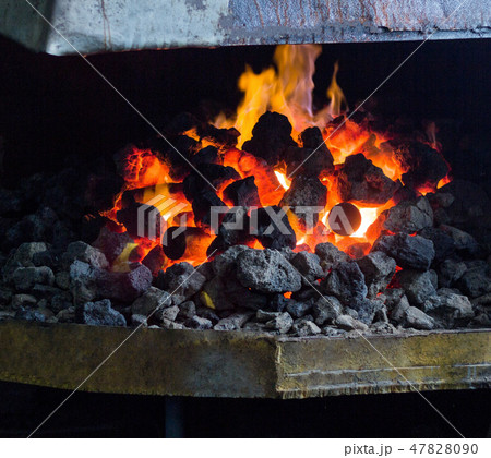 Fiery furnace with coal and hot metal parts for further processing, old forge, cooker 47828090