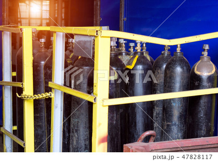 Black cylinders with oxygen are at the factory in the shop, a sunset is breaking through the window 47828117