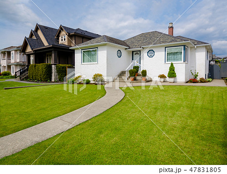 Main entrance of family house with concrete pathway over the yard on cloudy day Main entrance of family house with concrete pathway over the yard on cloudy day 47831805