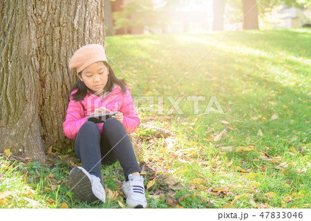 Asian cute girl using mobile phone in park, Asian cute girl using mobile phone in park, 47833046