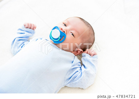 Adorable little newborn baby lying on white bed 47834721