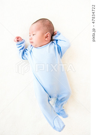 Newborn lovely cute baby lying on white bed sheet 47834722