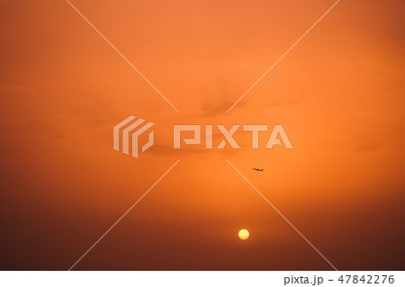 Dark silhouette of airplane in distance in air 47842276