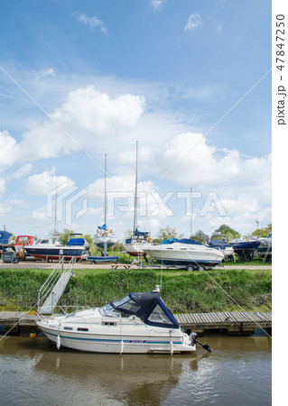 明るい青空の下　川沿いに停泊するボートと陸揚げされたヨット 47847250