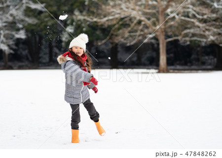 雪の降った公園で遊ぶ女の子の写真素材