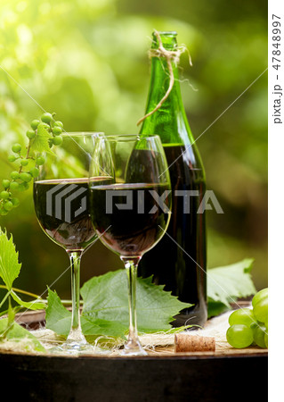 Red wine bottle and wine glass on wodden barrel. Red wine bottle and wine glass on wodden barrel. 47848997