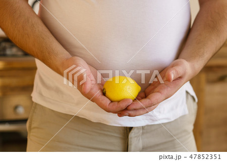 vegetarian overweight man with lemon in hands 47852351