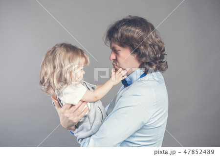 Happy smiling father holding on hands preschool daughter, looking at each other, father standing on 47852489