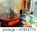 Orange chemical reaction inside a glass beaker 47853775