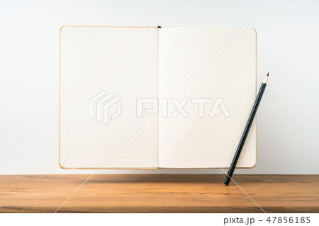 Perspective view of kraft notebook on wood floor 47856185