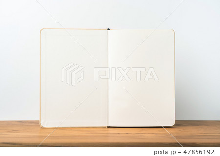 Perspective view of kraft notebook on wood floor Perspective view of kraft notebook on wood floor 47856192