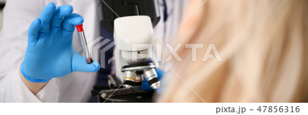 Male hand in blue protective gloves holding 47856316