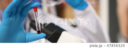 Male hand in blue protective gloves holding 47856320