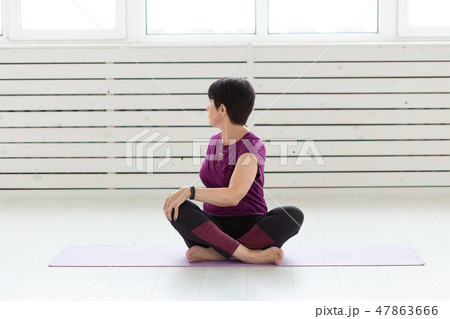Yoga, people concept - a middle-aged woman doing a yoga and try to do a asana 47863666