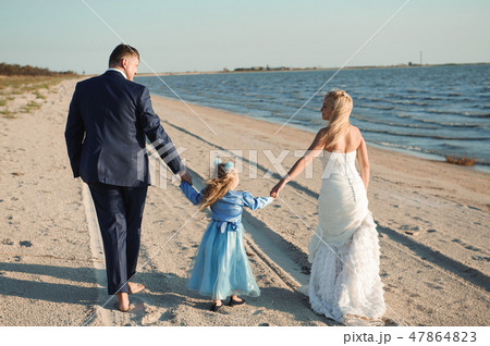 Happy family on a beach at sunrise - child mother and father. Happy family on a beach at sunrise - child mother and father. 47864823