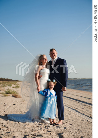 Happy family on a beach at sunrise - child mother and father Happy family on a beach at sunrise - child mother and father 47864880