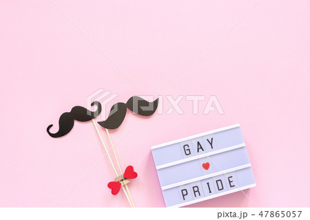 Lightbox text Gay pride and couple paper mustache props on pink background. Concept Homosexuality 47865057
