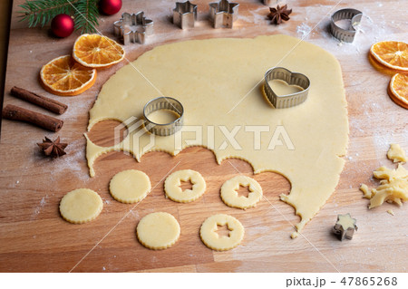 Cutting out shapes for Linzer Christmas cookies Cutting out shapes for Linzer Christmas cookies 47865268