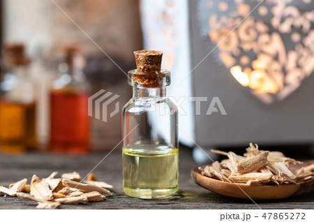 A bottle of cedar essential oil with cedar wood 47865272