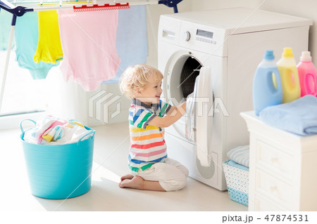 Child in laundry room with washing machine Child in laundry room with washing machine 47874531