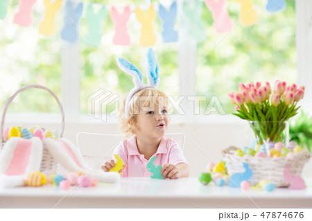 Kids on Easter egg hunt. Children dye eggs. 47874676