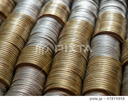 Horizontal row of silver coins and gold coins. 47874956