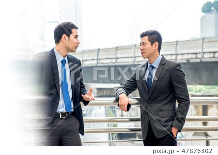 Asian businessmen talking together on a day break Asian businessmen talking together on a day break 47876302