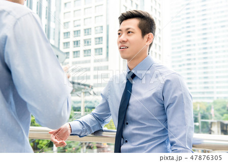 Asian Chinese businessman talking with colleague  47876305