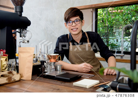 Asian entrepreneur barista sitting at counter Asian entrepreneur barista sitting at counter 47876308