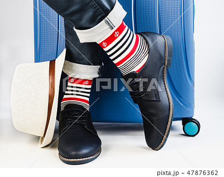 Stylish suitcase, men's legs, sun hat and socks 47876362